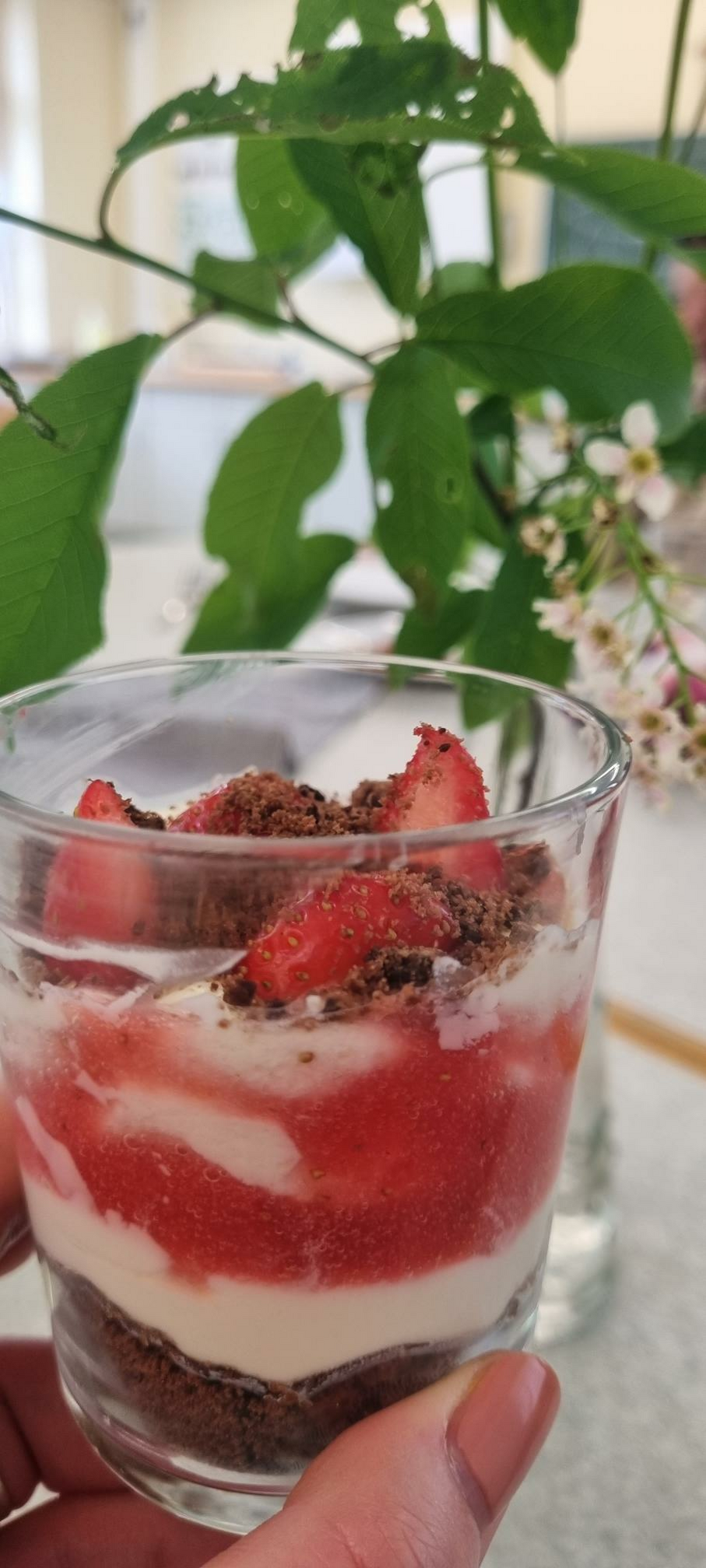 Ein Nachtisch mit Erdbeeren im Glas angerichtet.