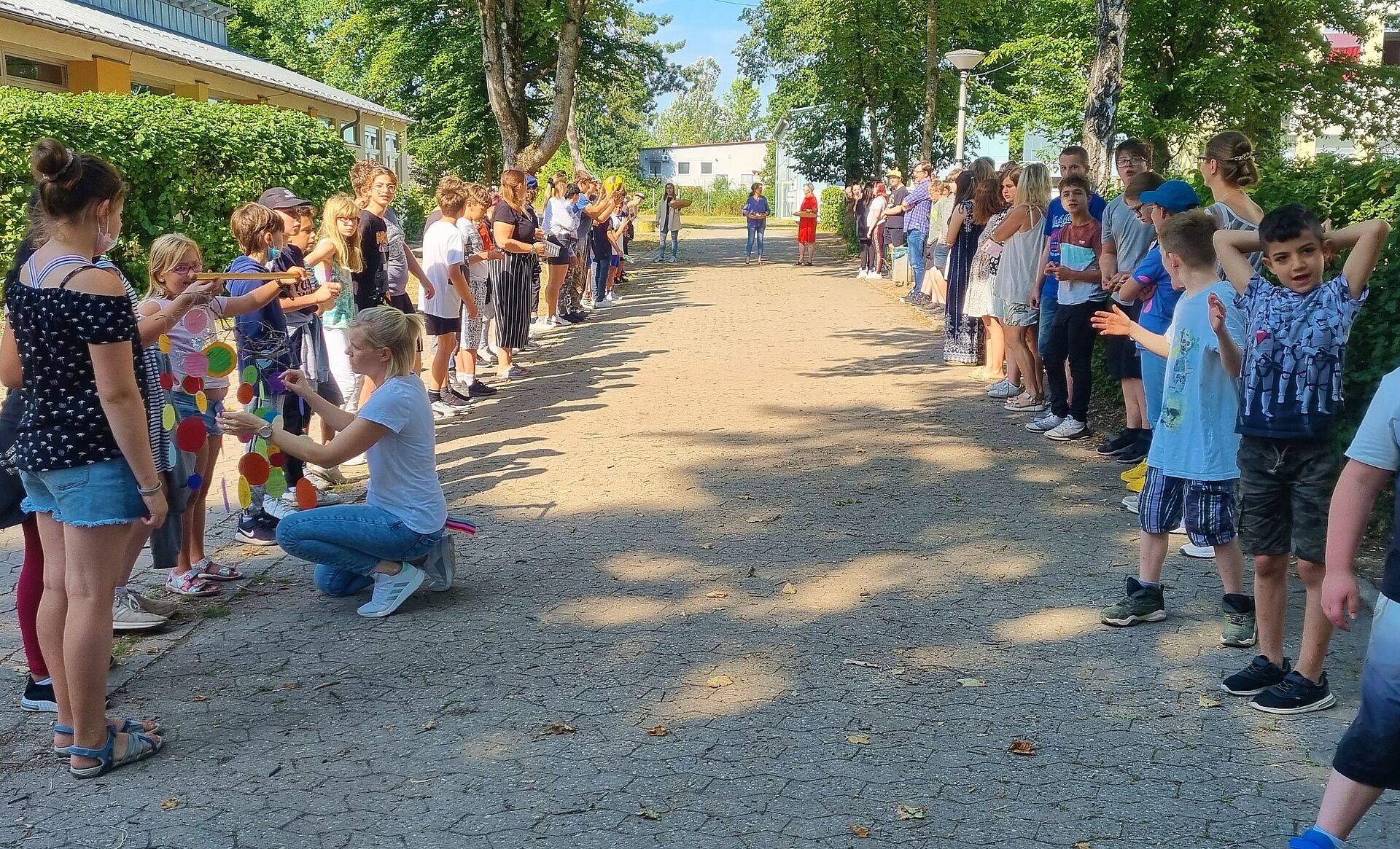 Die Schülerinnen und Schüler stehen am Pausenhof Spalier.