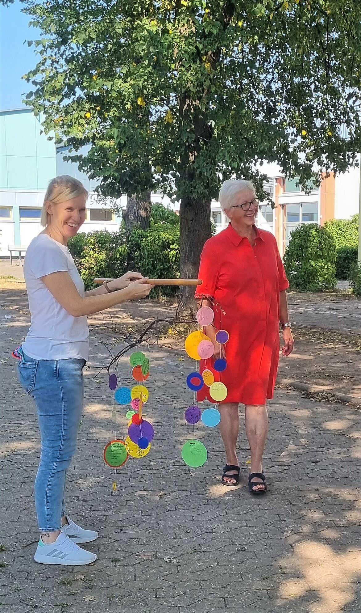 Frau Stephan-Mitesser erhält ein Geschenk der Schülerinnen und Schüler. Es ist ein buntes Mobile.